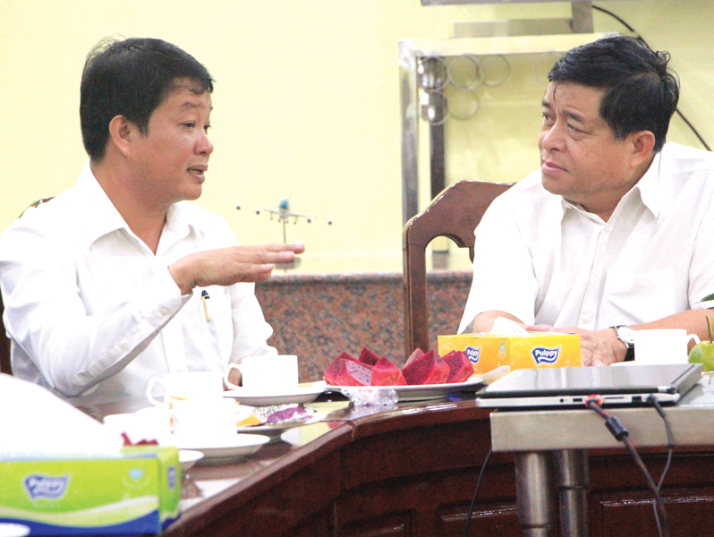 Bộ trưởng Bộ Kế hoạch và Đầu tư Nguyễn Chí Dũng (bên phải) trao đổi với đại diện Công ty Cát Tường