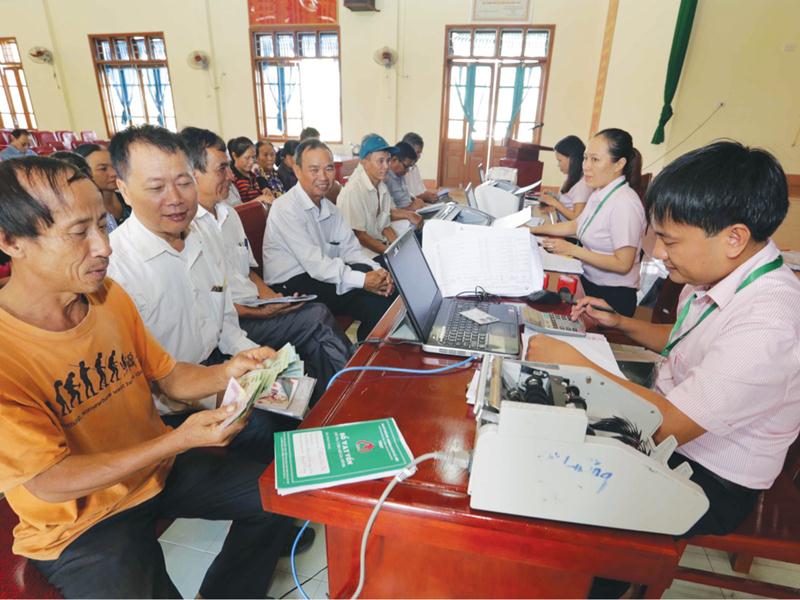 Các gia đình ở xã Thịnh Sơn, huyện Đô Lương (Nghệ An) đến Điểm giao dịch xã của ngân hàng Chính sách xã hội để nhận vốn vay cho con đi học