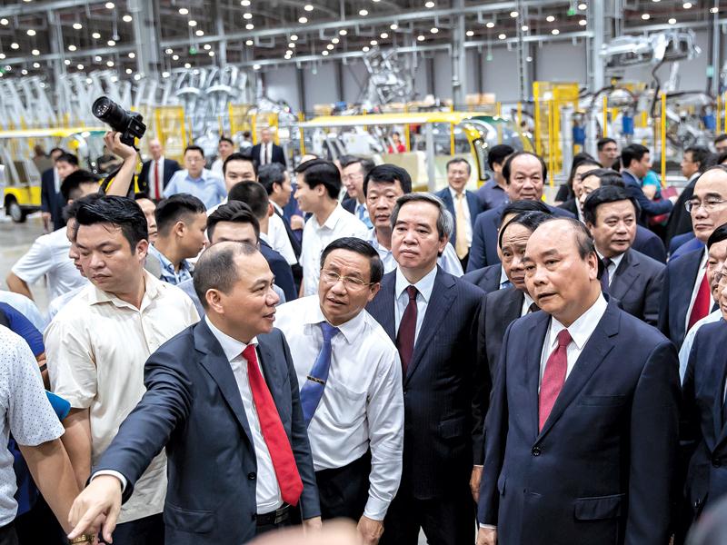 Ông Phạm Nhật Vượng giới thiệu Nhà máy Sản xuất ô tô VinFast với Thủ tướng Chính phủ Nguyễn Xuân Phúc và các quan khách.