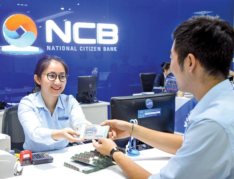 Đã có trên chục ngân hàng dâng lãi suất kỳ hạn dài lên trên 8%/năm. Trong ảnh: Giao dịch tín dụng tại ngân hàng NCB. Ảnh: Đức Thanh