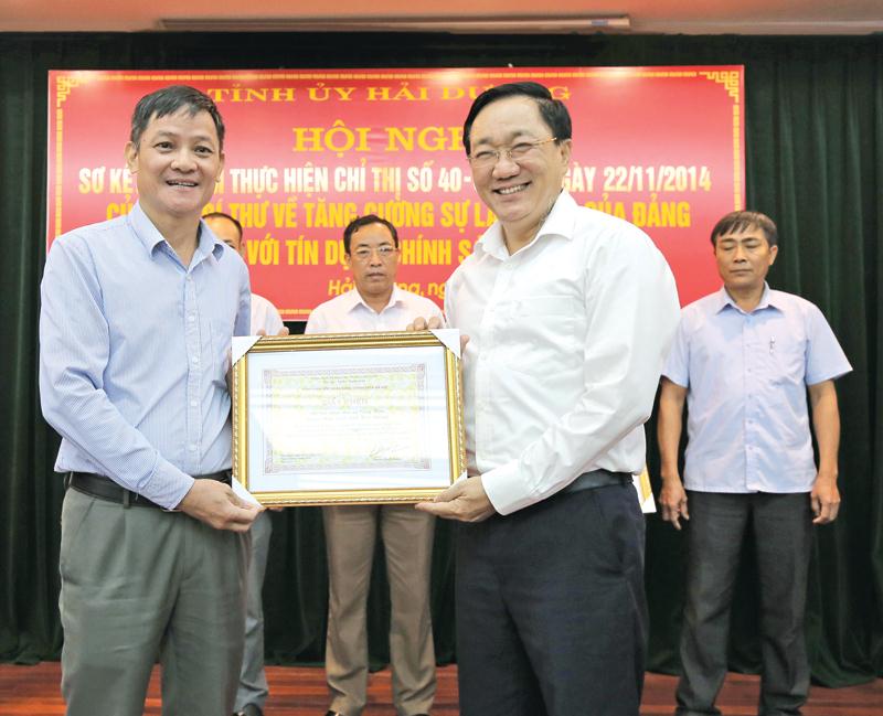 Tổng giám đốc NHCSXH Dương Quyết Thắng (bên phải) khen thưởng cá nhân có thành tích xuất sắc trong triển khai thực hiện Chỉ thị số 40-CT/TW
