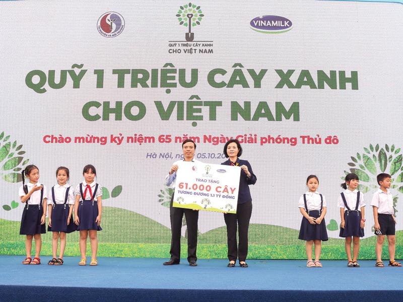 Bà Bùi Thị Hương, Giám đốc Điều hành Vinamilk trao bảng tượng trưng tặng 61.000 cây xanh cho đại diện TP. Hà Nội.