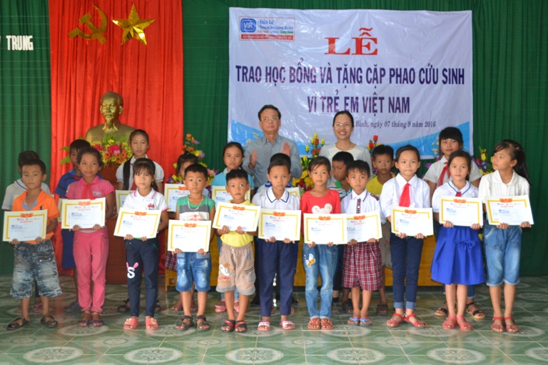 Phó Cục trưởng Cục Báo chí ông Nguyễn Thái Thiên và Phó Chủ tịch UBND huyện Lệ Thuỷ bà Ninh Thị Hoà trao học bổng cho các em học sinh. 