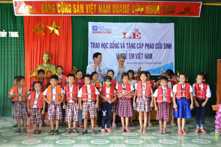 Lãnh đạo Báo Đầu tư trao cặp áo phao cho các em học sinh trên địa bàn huyện Lệ Thuỷ.