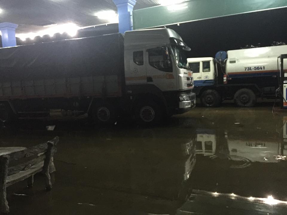 Nhiều xe tải dừng chân tại trạm xăng dầu chờ nước lũ xuống