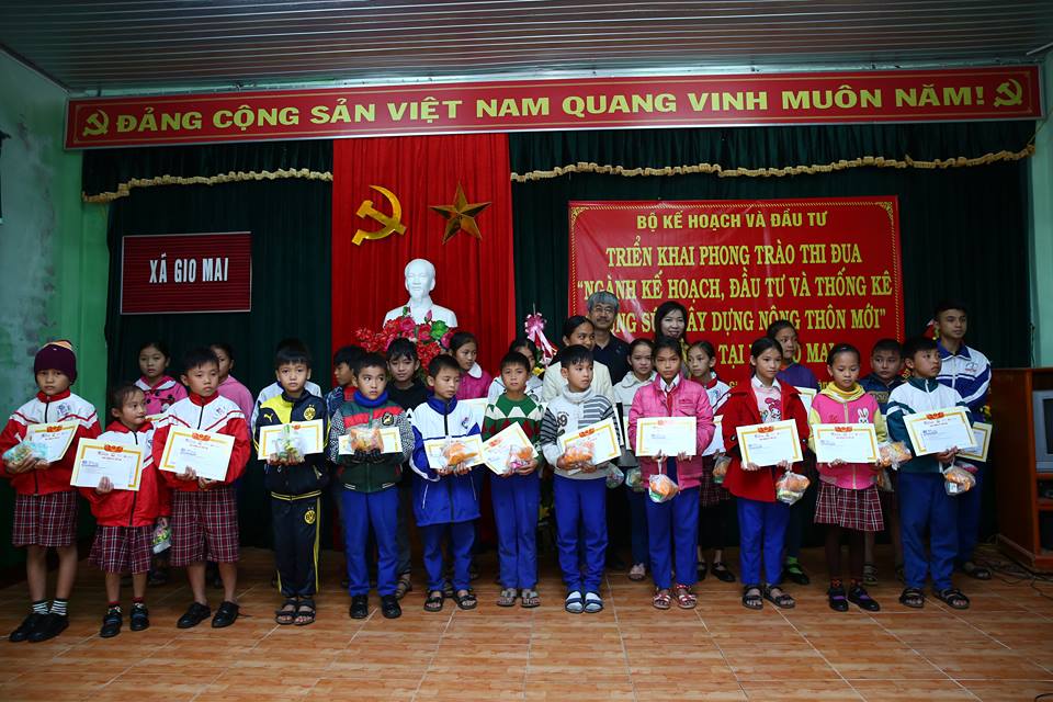 Phó Tổng biên tập Báo Đầu tư Nguyễn Quốc Việt và bà Bùi Thị Thu Hương, Phó Vụ trưởng Vụ Thi đua Khen thưởng và Truyền thông chụp hình lưu niệm với các em học sinh được trao học bổng