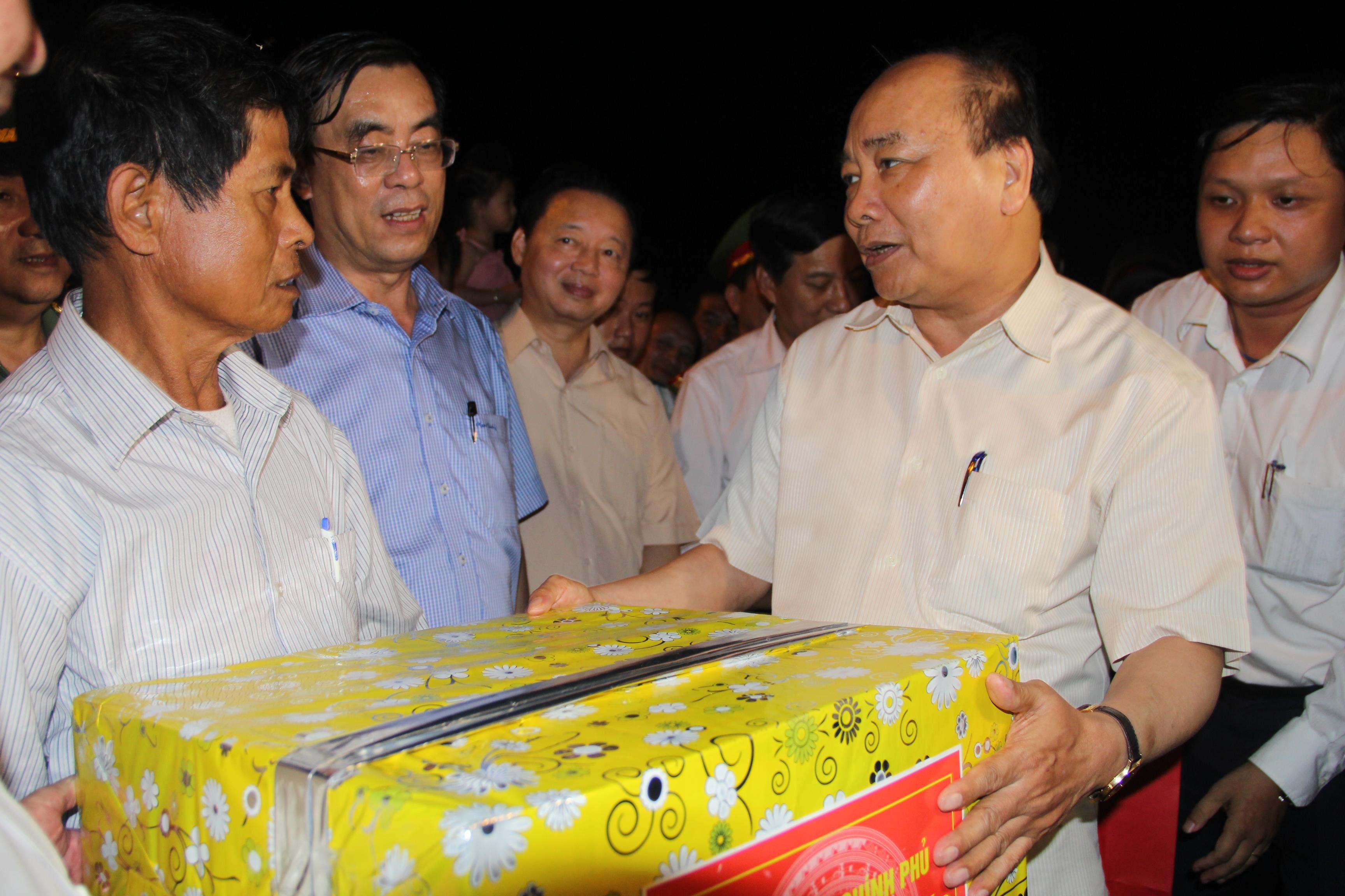 Thủ tướng Chính phủ Nguyễn Xuân Phúc tặng quà cho ngư dân tại cảng cá Cửa Việt.