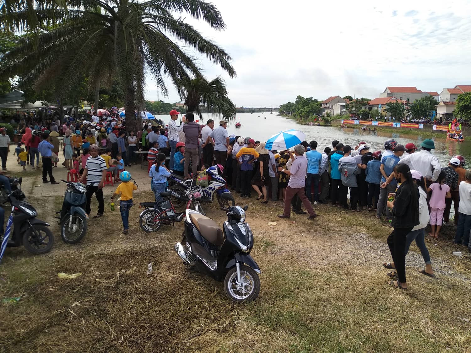 Người dân tập trung hai bên bờ sông Kiến Giang cổ vũ cho các đội đua.