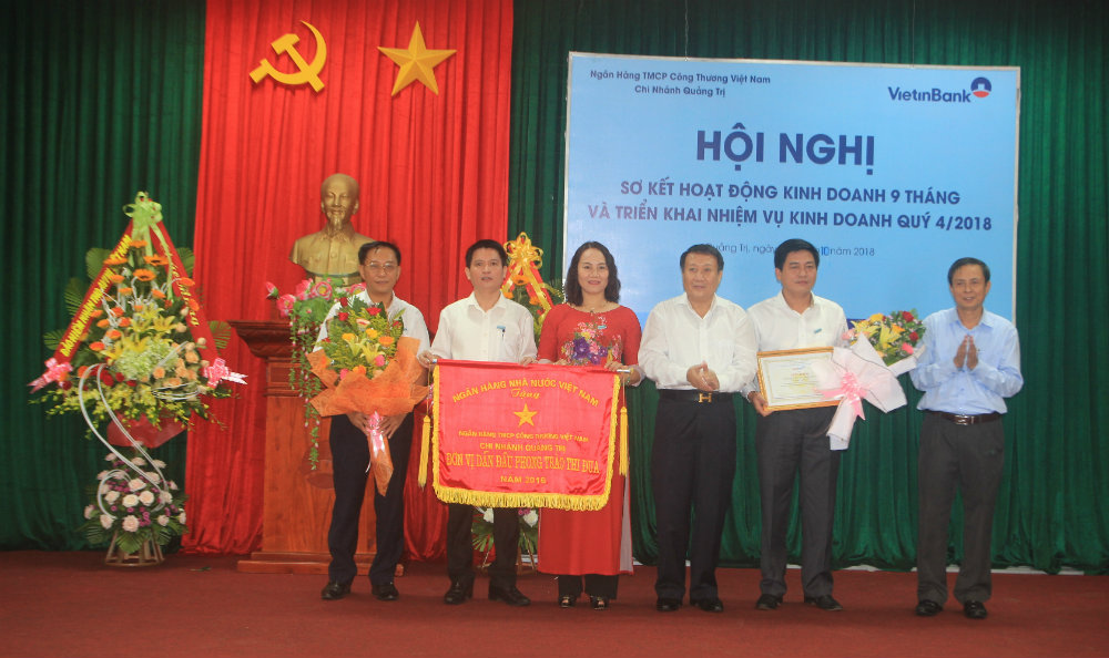 Phó Chủ tịch UBND tỉnh Quảng Trị Hà Sỹ Đồng trao cờ đơn vị dẫn đầu phong trào thi đua của ngân hàng thương mại cổ phần Công thương Việt Nam cho Vietinbank Quảng Trị
