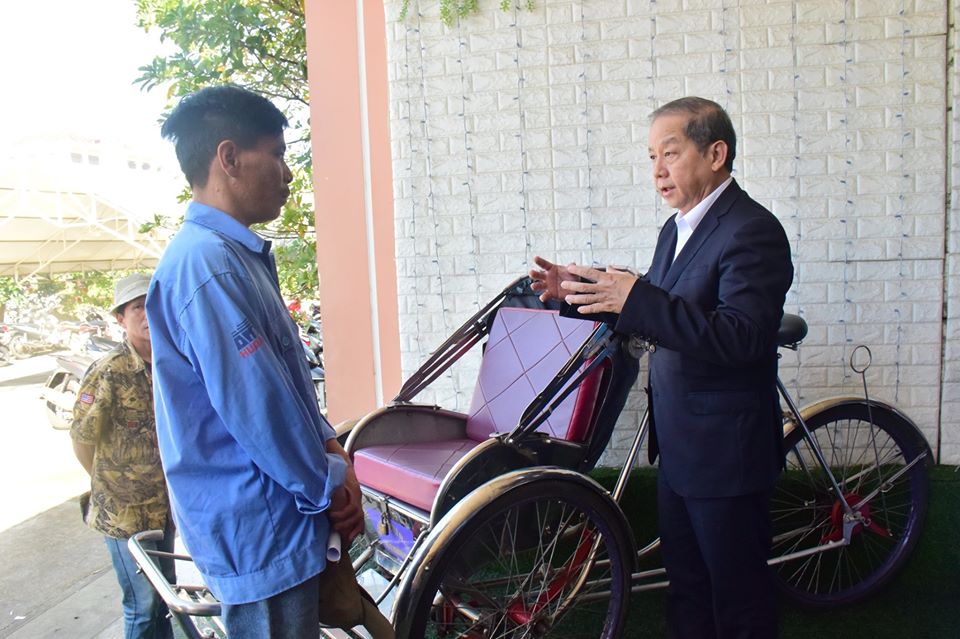 Chú tịch UBND tỉnh Thừa Thiên Huế Phan Ngọc Thọ trò chuyện cùng tài xế xích lô bên lề cuộc gặp.