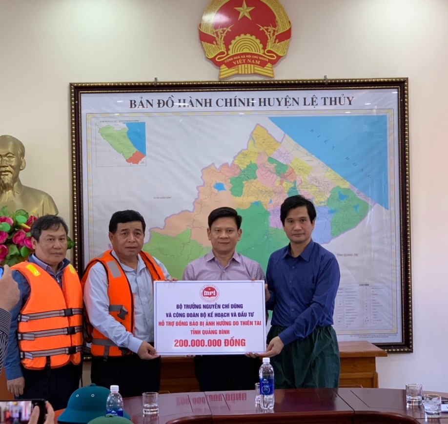 Bộ trưởng Nguyễn Chí Dũng trao số tiền 200 triệu đồng cho lãnh đạo huyện Lệ Thủy.