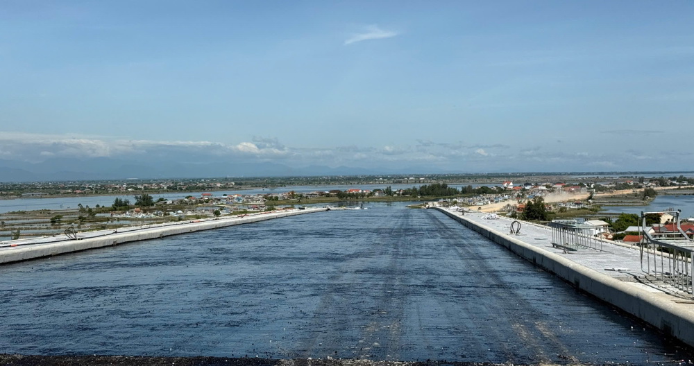 nhà thầu đang triển khai thảm nhựa phần đầu cầu Thuận An phía bờ nam