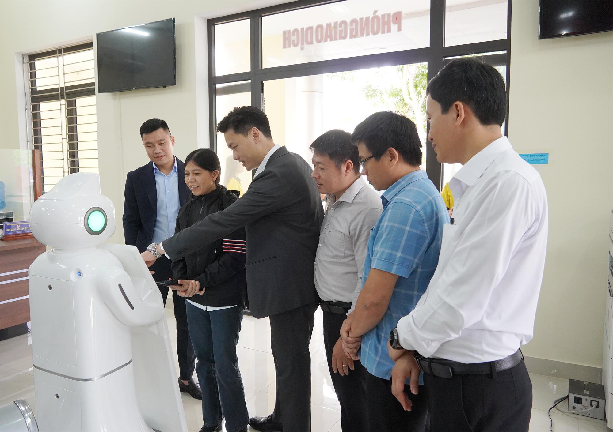 Người d&acirc;n v&agrave; c&aacute;c đại biểu trải nghiệm thực tế hoạt động của Robot lễ t&acirc;n tại Trung t&acirc;m Phục vụ h&agrave;nh ch&iacute;nh c&ocirc;ng tỉnh Quảng Trị