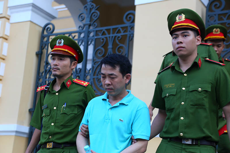 Bị cáo Nguyễn Minh Hùng áp tải ra xe đặc chủng sau phiên tòa 