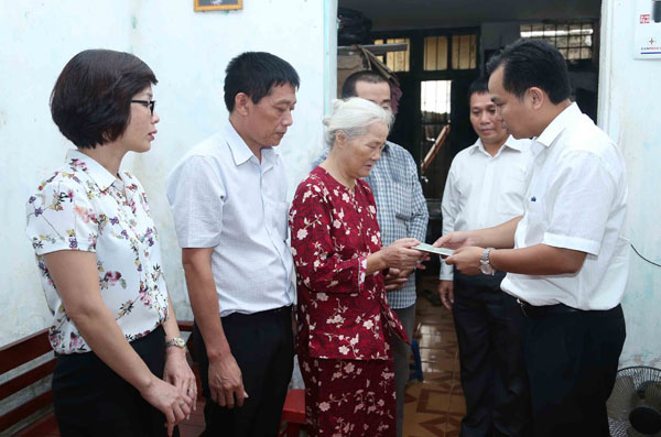 Đại diện đoàn thăm hỏi trao sổ tiết kiệm cho vợ liệt sỹ Nguyễn Mạnh Đề