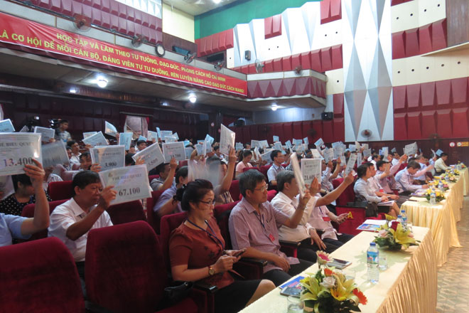 Các cổ đông giơ phiếu biểu quyết thông qua các tờ trình tại Đại hội (Ảnh: K>T)