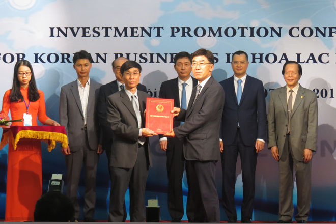 Ông Nguyễn Trung Quỳnh, Phó trưởng ban Ban Quản lý Khu CNC Hòa Lạc trao chứng nhận đầu tư cho đại diện Công ty DT&C (Ảnh: K.T)
