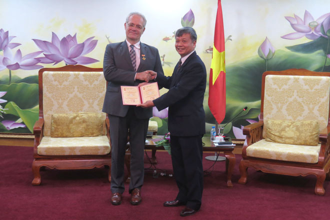 Thứ trưởng Bộ Kế hoạch và Đầu tư Nguyễn Thế Phương (bên phải) trao kỷ niệm chương cho ông Rémi Geneney (Ảnh: K.T)