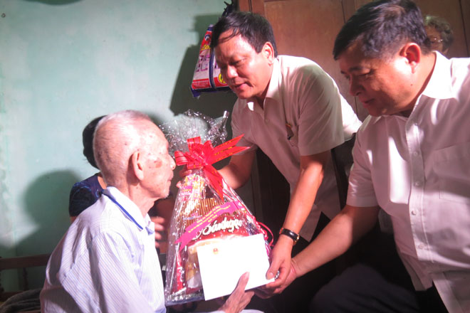 Bộ trưởng Nguyễn Chí Dũng thăm, động viên và tặng quà cho ông Phạm Văn Con, thương binh hạng 1/4 (Ảnh: K.T)