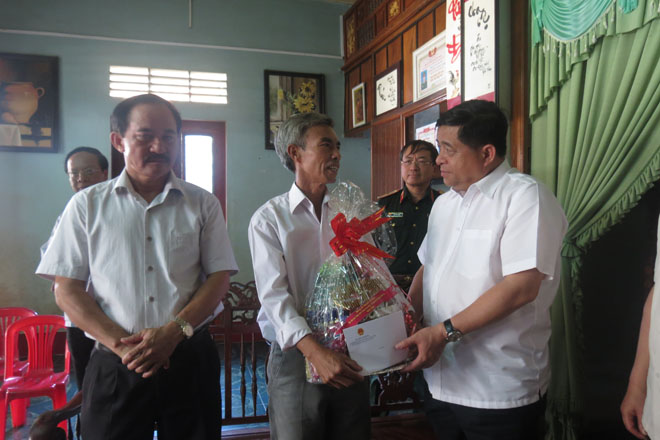 Bộ trưởng Nguyễn Chí Dũng và đoàn công tác thăm và tặng quà cho gia đình ông Trần Văn Bình (Thương binh hạng 4/4) tại thị trấn Khe Sanh, huyện Hướng Hóa (Ảnh: K.T)
