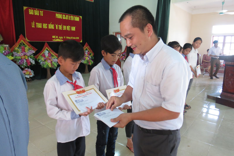 Ông Nguyễn Hữu Quang, Giám đốc truyền thông Tập đoàn BRG trao các suất học bổng cho các em học sinh