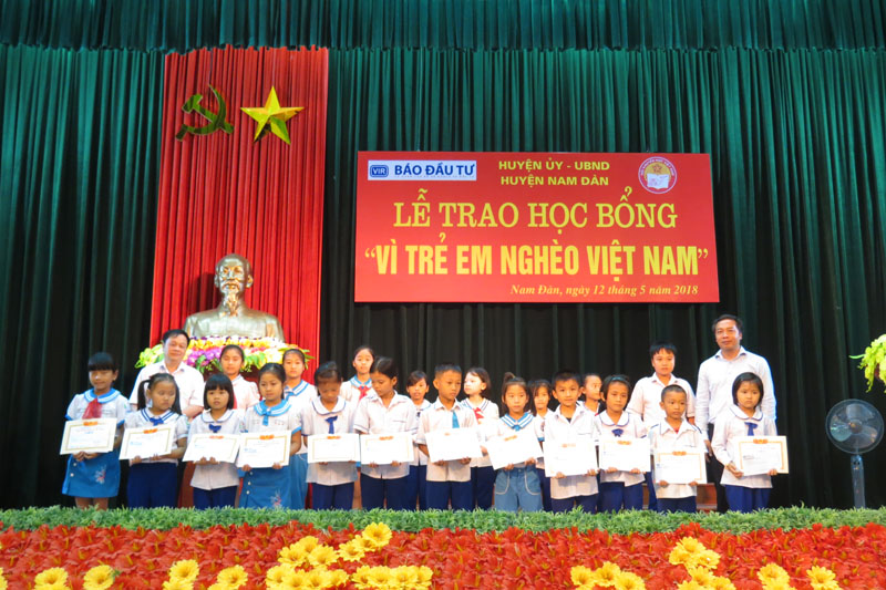 Ông Lê Trọng Minh cùng ông Nguyễn Lâm Sơn trao tận tay những suất học bổng cho các em học sinh