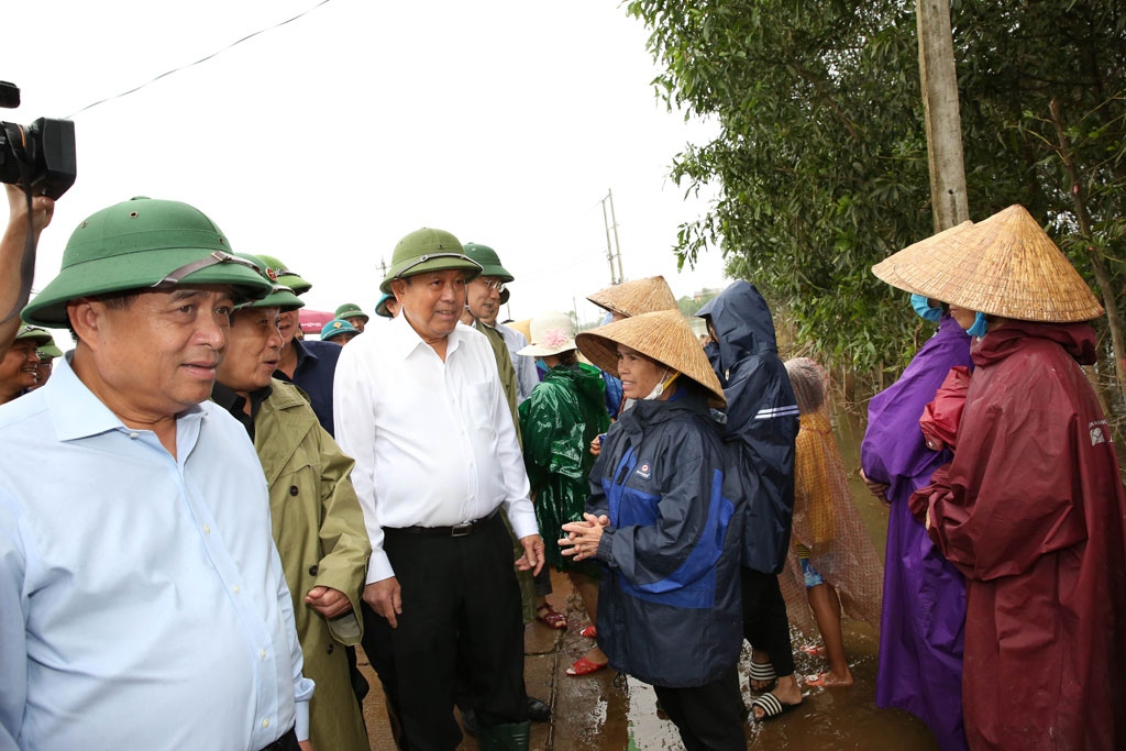 Bộ trưởng Nguyễn Chí Dũng (ngoài cùng bên trái) tham gia đoàn công tác của Phó Thủ tướng Trương Hòa Bình thị sát công tác khắc phục và động viên nhân dân xã Hải Định sớm ổn định cuộc sống. (Ảnh: VGP/Lê Sơn)