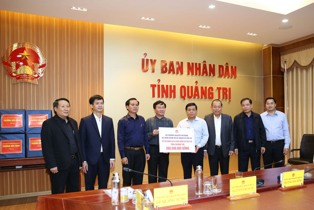 Bộ trưởng Bộ Kế hoạch và Đầu tư Nguyễn Chí Dũng trao quà hỗ trợ tỉnh Quảng Trị. (Ảnh: VGP/Lê Sơn)