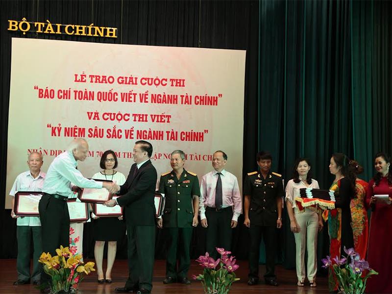 Bộ trưởng Bộ Tài chính Đinh Tiến Dũng (bìa phải) trao Giải A cho GS.TSKH Nguyễn Mại với tác phẩm: “Chính sách thuế đối với doanh nghiệp: hướng tới mục tiêu kép”.