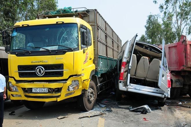 Xe khách bị tông mắc kẹt giữa hai xe tải.