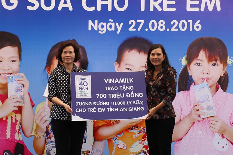Bà Bùi Thị Hương-Giám Đốc Điều Hành Vinamilk trao tặng bảng tượng trưng 700 triệu tương đương 111.000 ly sữa của Quỹ Sữa Vươn Cao Việt Nam cho trẻ em nghèo tỉnh An Giang.