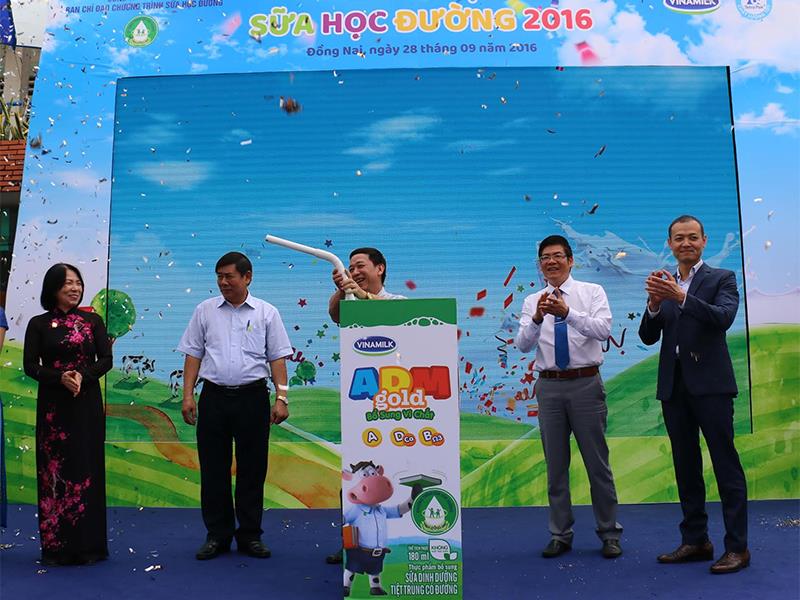 Các đại biểu tham dự chương trình cùng thực hiện nghi thức cắm ống hút vào hộp sữa để chính thức khởi động chương trình Sữa học đường Quốc gia tại tỉnh Đồng Nai do Vinamilk và Tetra Pak tổ chức.