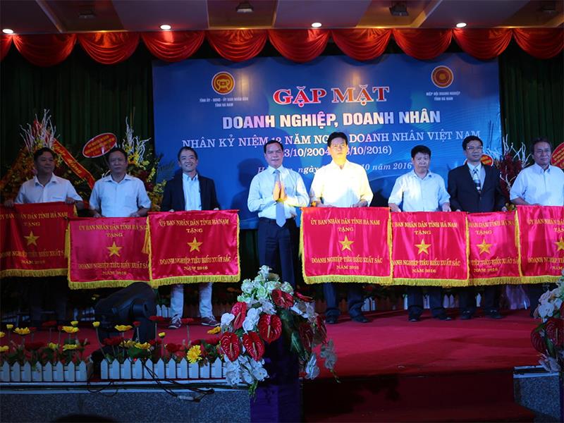 Bí thư Tỉnh ủy Hà Nam Nguyễn Đình Khang trao Cờ thi đua của UBND tỉnh cho các doanh nghiệp.