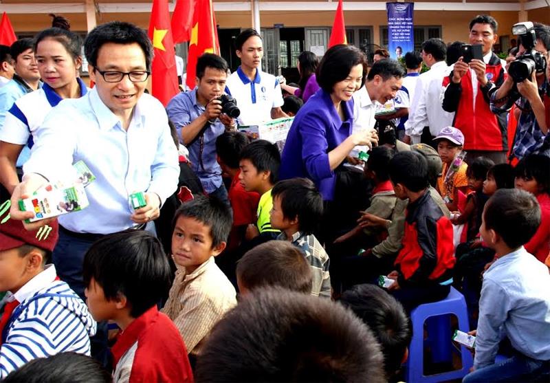 Phó Thủ tướng Vũ Đức Đam và bà Bùi Thị Hương – Giám Đốc Điều hành Vinamilk đang trao sữa học đường của Vinamilk cho học sinh trường tiểu học dân tộc khó khăn nhất của tỉnh Đắk Nông.