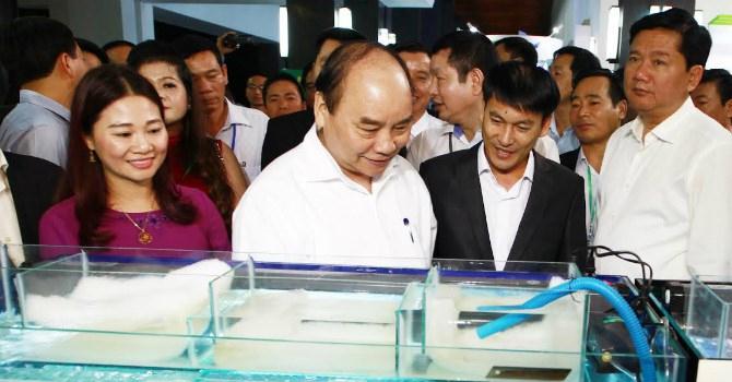 Thủ tướng Nguyễn Xuân Phúc tham quan gian hàng tôm giống của Công ty TNHH Đầu tư thủy sản Nam Miền Trung tại hội nghị xây dựng nền Công nghiệp Nông nghiệp Việt Nam.