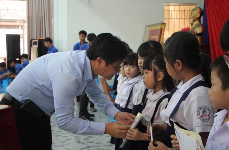 Ông Nguyễn Văn Hồng, Phó Tổng biên tập Báo Đầu tư trao học bổng cho các em học sinh.