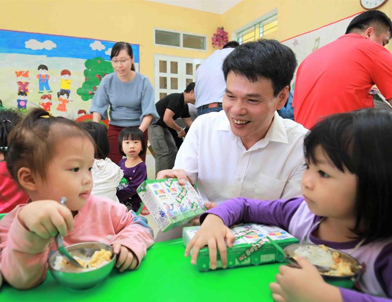 Ông Phạm Tuyên - Giám đốc Kinh doanh miền Bắc Công ty Cổ phần Sữa Việt Nam trao sữa cho các em nhỏ Trường mầm non Hoa Phượng, phường Cầu Thia, tỉnh Yên Bái.