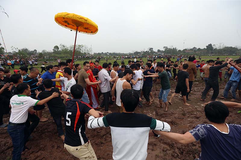 Cụ chủ tế hai tay ôm chặt trái Phết để đến địa điểm thả trong sự bảo vệ nghiêm ngặt của lực lượng thanh niên tham gia bảo vệ