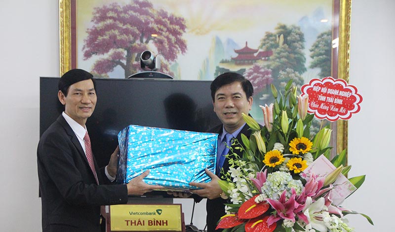 Chủ tịch Hiệp hội doanh nghiệp Thái Bình Đỗ Văn Vẻ tặng hoa và quà cho ngân hàng Thương mại cổ phần Ngoại thương chi nhánh Thái Bình (VietcomBank Thái Bình).