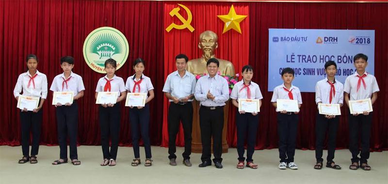 Ông Ngô Đức Sơn (thứ 5 từ phải qua), Phó Tổng Giám đốc DRH Holdings cùng ông Đặng Hồng Sinh, Phó Trưởng phòng GD&ĐT huyện Hàm Tân, trao học bổng cho các em học sinh.