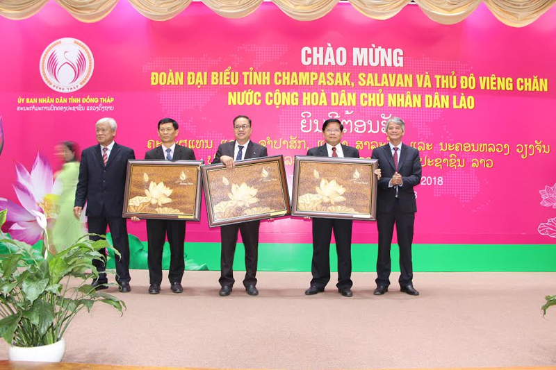 Đoàn Đại biểu nước Lào và Đồng Tháp trao nhau những bức tranh và quà lưu niệm mang đậm bản sắc dân tộc.