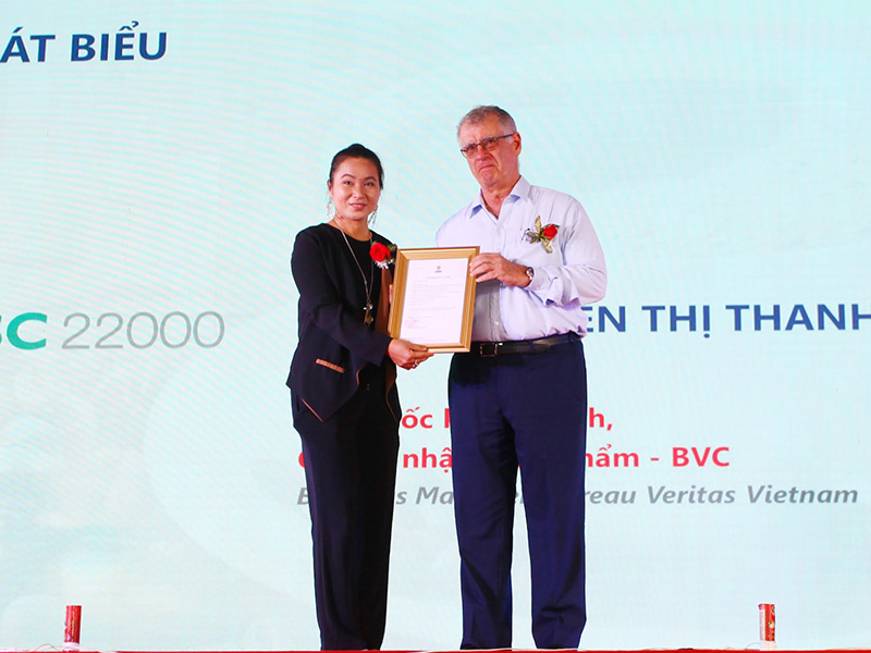 Bà Nguyễn Thị Thanh Hương (trái) giám đốc kinh doanh tổ chức chứng nhận thực phẩm BVC trao chứng nhận tiêu chuẩn FSSC 2000 cho Celso Sgarbi Garcia tổng giám đốc cà phê Tín Nghĩa.