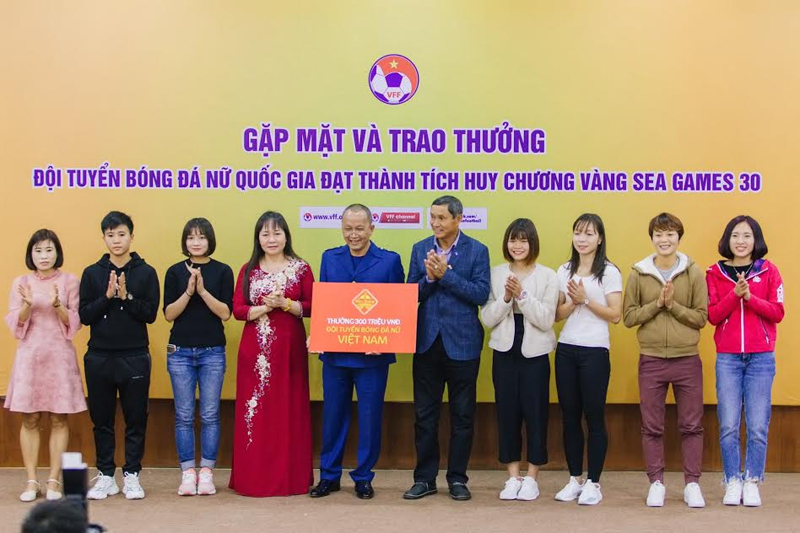 Bà Phan Thị Châm, Chủ tịch HĐQT Công ty CP Quốc tế Bảo Hưng (áo dài đỏ) thưởng đội tuyển bóng đá nữ Việt Nam Việt Nam 300 triệu đồng.