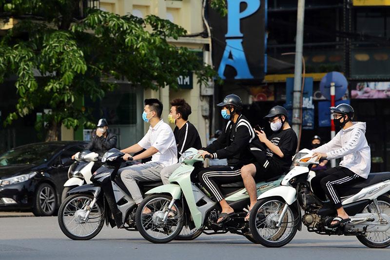 Một nhóm thanh niên tham gia giao thông nhưng vẫn có người không quan tâm tới sự an toàn của bản thân bằng việc không đội mũ bảo hiểm.