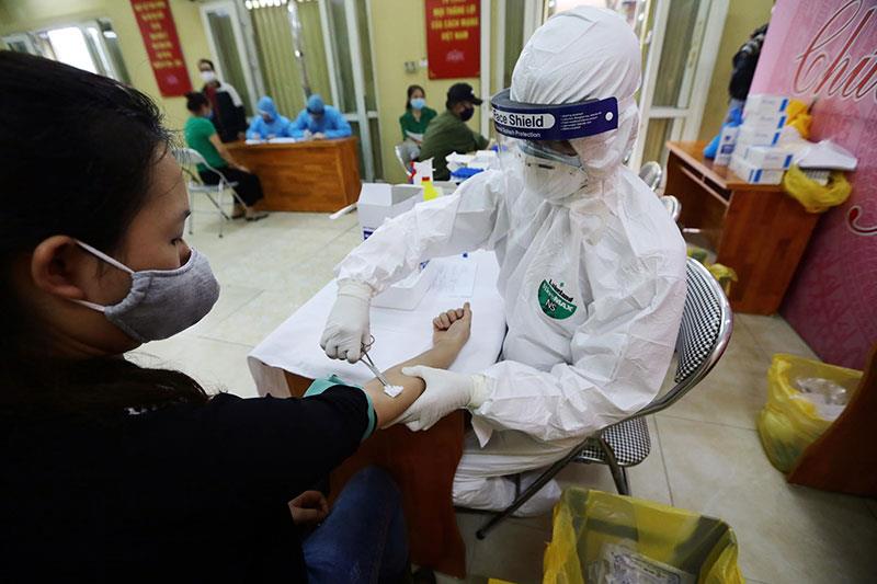 Các cán bộ y tế của quận Ba Đình lấy mẫu xét nghiệm cho người kinh doanh chợ Long Biên.