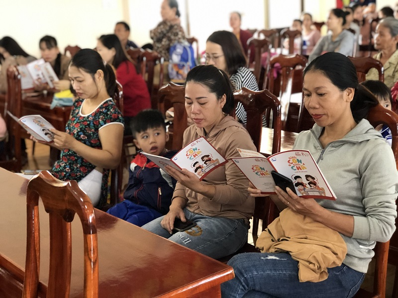 Các vị phụ huynh tại Đắk Lắk chăm chú đọc bộ tài liệu với nhiều thông tin nuôi, dạy trẻ hữu ích được phát miễn phí tại hội thảo.