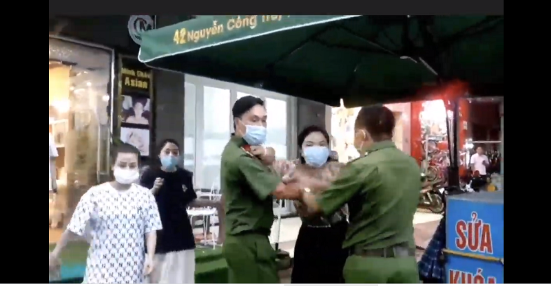 Người phụ nữ tại Thẩm mỹ viện Minh Châu Asian hành hung phóng viên trước mặt 2 cán bộ công an. Ảnh: Cắt từ clip