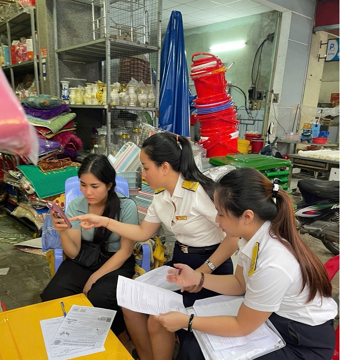 C&aacute;n bộ Thuế TP Đ&agrave; Nẵng hướng dẫn c&aacute;c hộ kinh doanh thực hiện nghĩa vụ thuế đối với Nh&agrave; nước. Ảnh: Trương Việt
