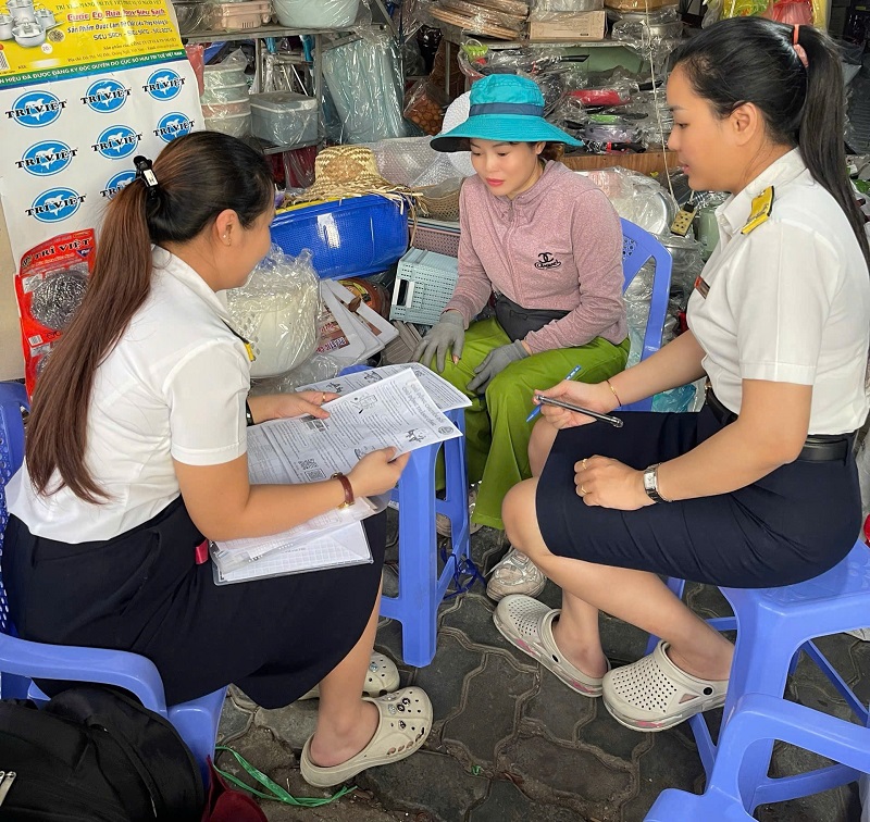 Cán bộ Thuế TP Đà Nẵng hướng dẫn các hộ kinh doanh thực hiện nghĩa vụ thuế đối với Nhà nước. Ảnh: Trương Việt