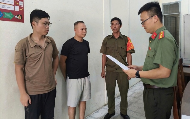 Cơ quan An ninh điều tra C&ocirc;ng an th&agrave;nh phố Đ&agrave; Nẵng tống đạt c&aacute;c quyết định đối với Chu Đức Anh (&aacute;o đen) v&agrave; Nguyễn Trung Hiếu (ngo&agrave;i c&ugrave;ng b&ecirc;n tr&aacute;i).